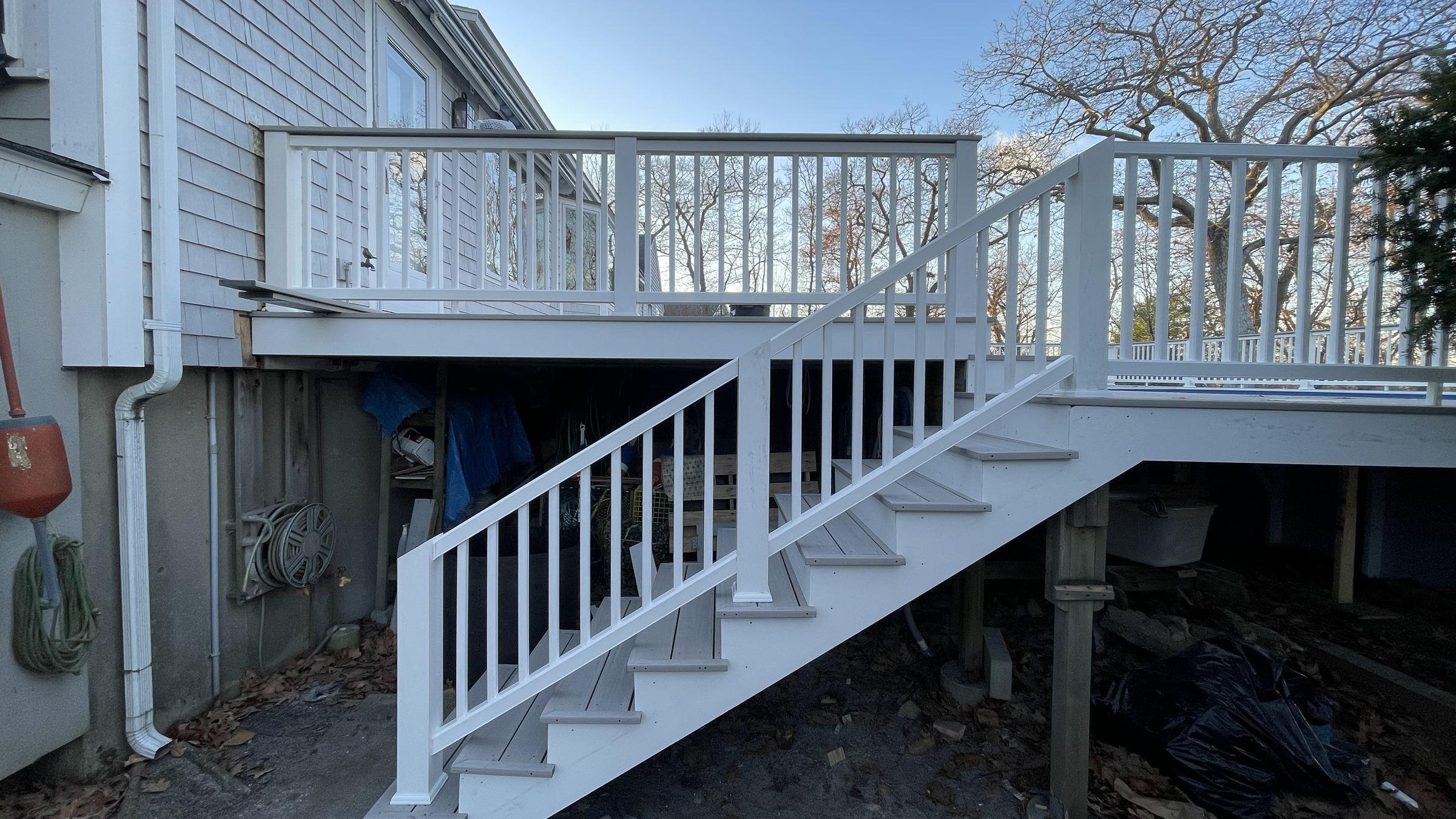 Composite deck stairs with white railings by Masterline Carpentry in Scituate, MA